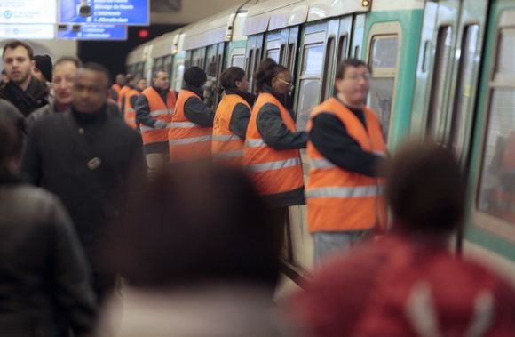 AFP/Scanpix nuotr./Paryžiaus metro gyventojai padeda uždaryti traukinio duris