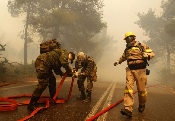 Ugniagesiai ir savanoriai kovoja su miškų gaisrais Graikijoje.