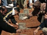 „Reuters“/„Scanpix“ nuotr./Sukilėliai laidoja žuvusiuosius.