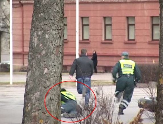 Kadras ia etaplius.lt filmuotos medžiagos/Bėglio gaudynių akimirka: vienas ia pareigūnų posūkyje griuvo.