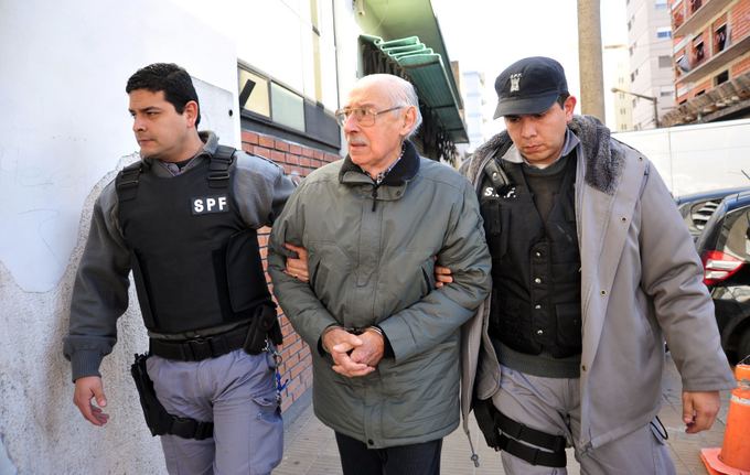 Jorge Rafaelį Videlą veda Argentinos policininkai. (2012 m. nuotr.)