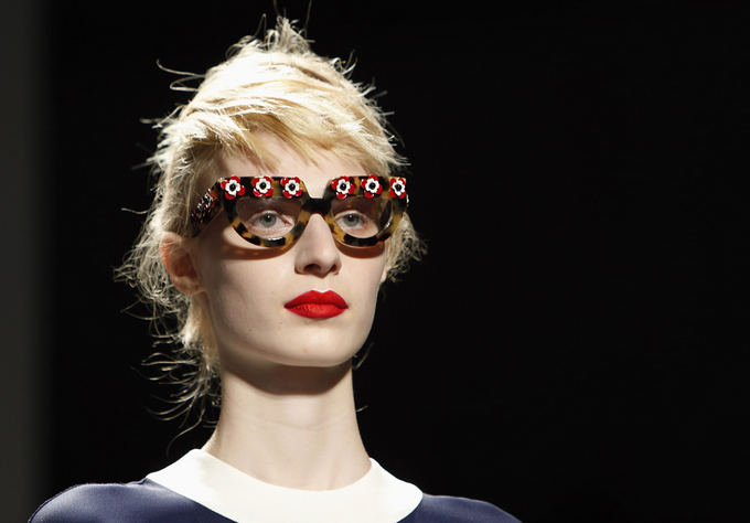  Prada pavasario/vasaros 2013 m. kolekcija Milano mados savaitėje. Mados namai kolekcijos metu nusprendė demonstruoti akinius be tamsių stiklų, iaryakindami natūraliai padažytas merginų akis ir sodrius lūpų raudonius. 