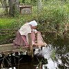 Moteris skalbia kūdroje