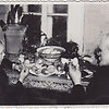 Fotonuotrauka. Senelis (de&scaron;inėje) su anūku (kairėje) dažo velykinius margučius prie uždaroje patalpoje esančio stalo. XX a. 3&ndash;4 de&scaron;. (Trakų muziejus, CC BY)