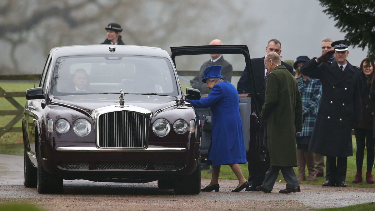 Karalienė Elizabeth II ir princas Philipas lipa į automobilį.