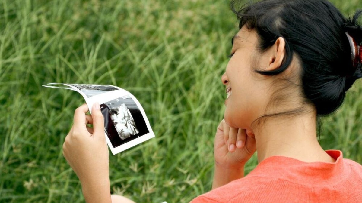 Būsima mama, žiūrinti į ultragarso nuotrauką