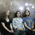 Members of the female punk band "Pussy Riot" (R-L) Nadezhda Tolokonnikova, Yekaterina Samutsevich and Maria Alyokhina sit in a glass-walled cage after a court hearing in Moscow, August 17, 2012. A judge sentenced three women who staged an anti-Kremlin protest on the altar of Moscow's main Russian Or