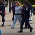 Įvykio vietoje policijos pareigūnai veda sulaikytą moterį.
