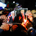 Ramaloje protestuojantys palestiniečiai degina D.Trumpo ir B.Netanyahu nuotrauką.
