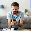 Telefonu besinaudojantis vyras