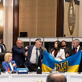 Ukrainos delegacijos nariai i&scaron;skleidžia savo &scaron;alies vėliavą &scaron;alia Rusijos delegacijos vadovės pavaduotojos Olgos Timofejevos