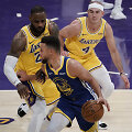 Stephenas Curry (su kamuoliu) prie&scaron; &bdquo;Lakers&ldquo; gynybą