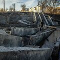 Vietinis gyventojas bando pereiti per sugriautą tiltą Bachmuto mieste