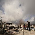 Palestiniečiai apžiūri apdegusį automobilį po to, kai jį, kaip įtariama, padegė izraeliečiai
