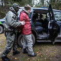 Pasieniečiai &scaron;alia Piesčių kaimo (Varėnos r.) į tarnybinį automobilį sodina sulaikytą migrantą 