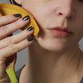 Moteris banano žieve trina sau veidą