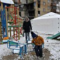 Vaikas žaidžia &scaron;alia apgriautų namų Kyjivo regione