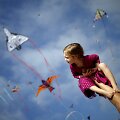 Tėtis laiko mergaitę ant rankų per aitvarų festivalį Kalifornijoje