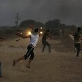 Palestiniečiai mėto akmenis į Izraelio pareigūnus.