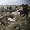 Palestinečiai apžiūri i&scaron;kasinėtus kapus Gazos Ruože.
