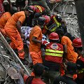 Gelbėtojai dirba pastato griuvėsiuose Pakistane