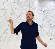 Menininkas Tomas Saraceno prie savo kūrinio Paryžiuje