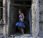 Mergina su savo daiktais i&scaron;eina i&scaron; Donecke ap&scaron;audyto daugiabučio