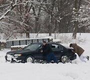 Stumiamas sniege užklimpęs automobilis