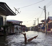 Vaikas žaidžia patvinusioje Amazonės upės vandenyje Brazilijoje