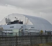 Černobylyje naujas milžini&scaron;kas gaubtas pradėtas stumti ant branduolinio reaktoriaus
