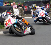 M.Dunlopas (1 numeris) pirmauja prie&scaron; Guy Martin (2 numeris) 2012 m. &bdquo;Isle of Man Southern 100&ldquo; lenktynėse. Agljones nuotr. Wikipedija. CC BY-SA 3.0