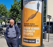Signataras Petras Vaitiekūnas prie reklaminio stendo