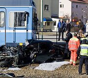 Gelbėtojai apžiūri sudaužytą automobilį.