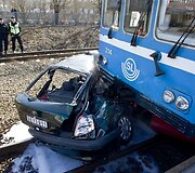 Automobilio priekis palindęs po traukiniu.