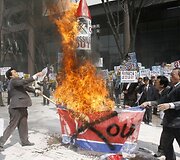 Protesto akcijos dalyviai degino &Scaron;.Korėjos vėliavas ir raketos modulį.