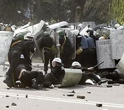 Policininkai bėga nuo įsiutusios minios.