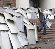 Policininkai nuo svaidomų plytų slepiasi po skydais.
