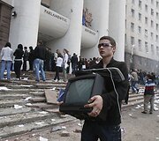 Vaikinas ne&scaron;asi televizorių i&scaron; parlamento.