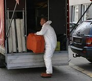 Cheminių incidentų likvidavimo darbuotojas traukia darbo įrankius.