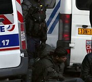 Policininkas stovi &scaron;alia suimto protestuotojo.
