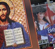 Jėzaus plakatas &scaron;alia eurovizijos plakato.