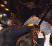 Policininkas protestuotojui trenkia lazda.