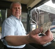 Vairuotojas demonstruoja akmenį, su kuriuo buvo i&scaron;daužtas langas.