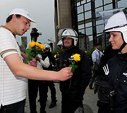 Ūkininkas dovanoja rožę policininkei.