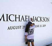 Mergaitė pirmoji pasira&scaron;o ant Michaelo Jacksono plakato.