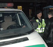 Policininkas kalbasi su akcijos organizatoriumi Dariumi Kasperaičiu
