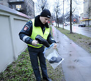 Policininkas renka žuvusiojo daiktus