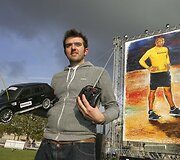 Ianas Cookas pozuoja prie savo kūrinio.