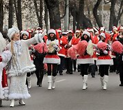 Parade dalyvauja &scaron;okėjos ir muzikantai.