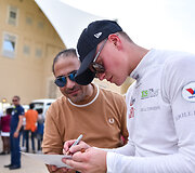 Rokas Baciu&scaron;ka Abu Dabyje dalijo autografus Pasaulio ralio kroso čempionato žiūrovams